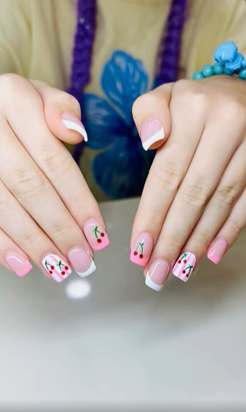 Pink French-tip nails with hand-painted cherry nail art